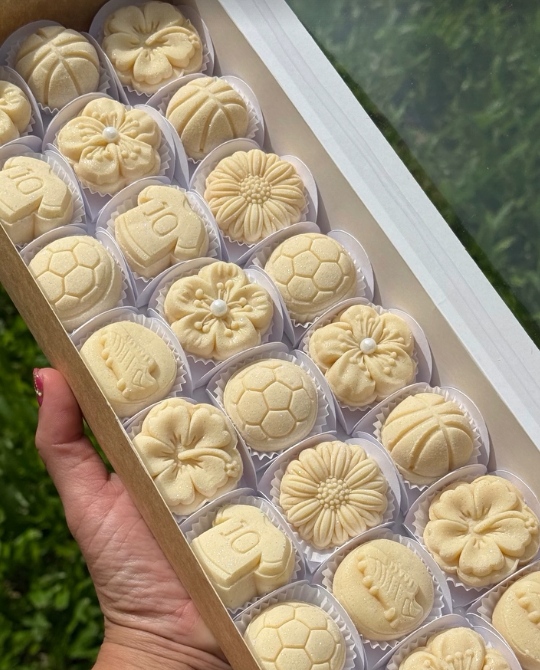 Caja de brigadeiros artesanales con flores y diseños en blanco